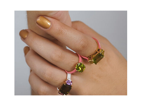 3 stone ring, emerald cut peridot with two yellow sapphires set in 18 karat yellow gold. Pink ceramic along the ring shank.