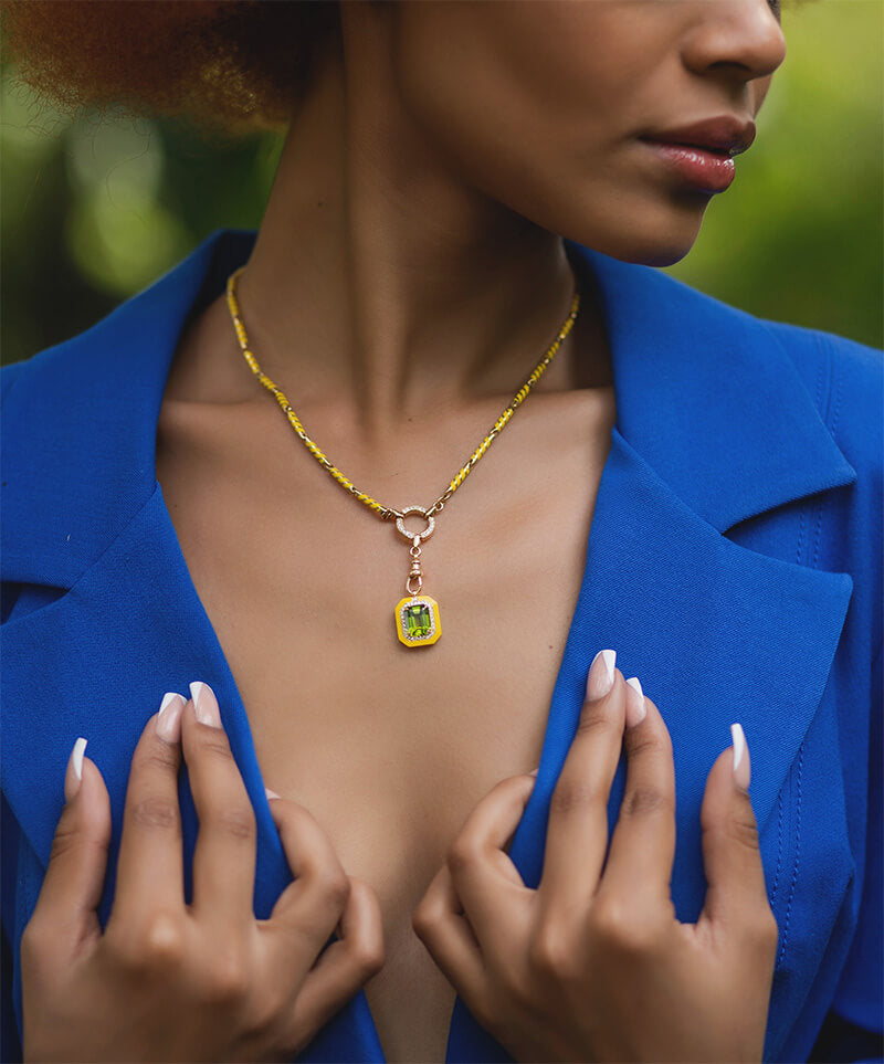 model wearing an 18 carat gold chain with diamonds and yellow ceramic