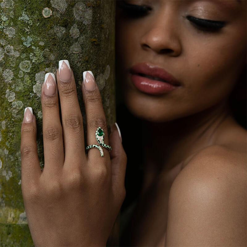 model wearing snake ring with colombian emerald and diamonds set in 18 carat gold and green and black ceramic